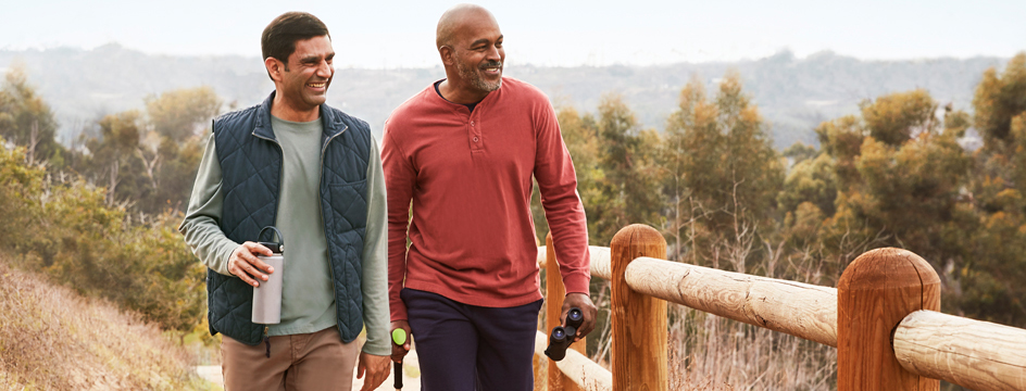 Two men walk hiking trail together, ready to go birdwatching